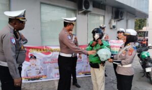 Dirlantas Polda Sulteng Kombes Pol. Atot Irawan membagikan helm SNI