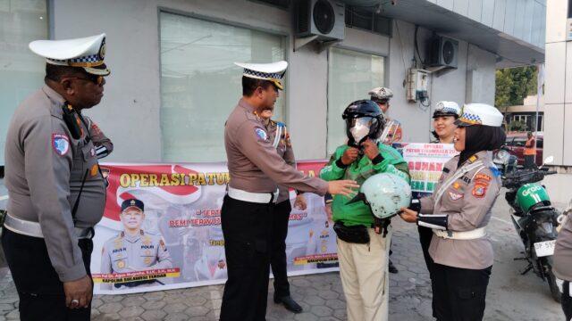 Dirlantas Polda Sulteng Kombes Pol. Atot Irawan membagikan helm SNI